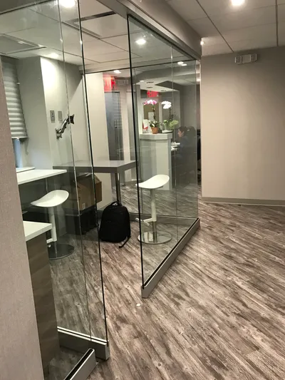 Glass-walled treatment rooms with wood-look flooring